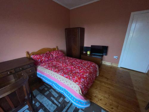 sypialnia z łóżkiem z czerwoną kołdrą w obiekcie Lovely double room in very good area w Edynburgu