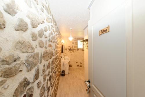 a hallway with a stone wall next to a door at Nuits D'y Cîmes : Nuit Insolite Bulle, SPA in Jaunac