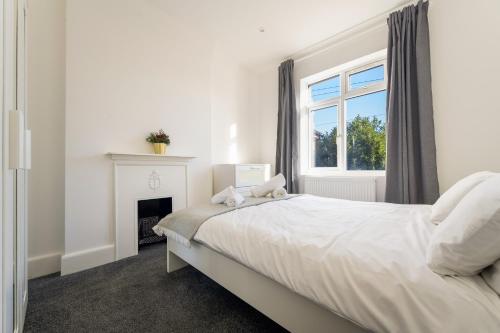 a white bedroom with a bed and a fireplace at Boho Nest in Bournemouth