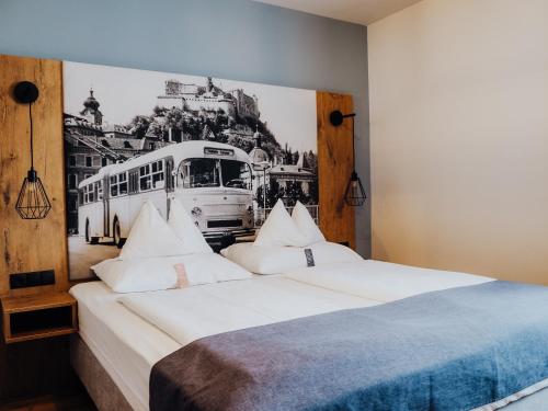 a bedroom with two beds with a bus painting on the wall at Levy's Rooms & Breakfast in Salzburg