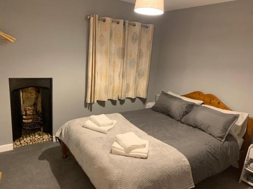 a bedroom with a bed with two towels on it at Pant-y-creolen in Llanfyllin