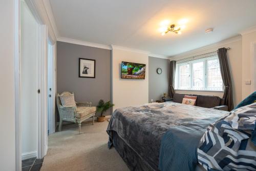 a bedroom with a bed and a chair and a window at Airstays Apartment in Wythenshawe