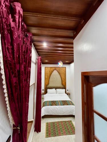 a bedroom with a bed with red curtains at Riad el wazania in Rabat
