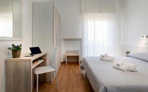 sypialnia z łóżkiem i biurkiem z komputerem w obiekcie Hotel Kursaal w mieście Bellaria-Igea Marina