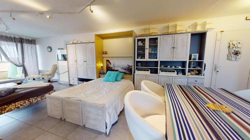 une grande chambre avec deux lits et un canapé dans l'établissement Plein Sud magnifique vue 180 face mer, à Les Bussolleries