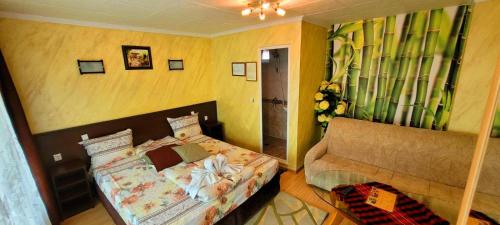 ein kleines Schlafzimmer mit einem Bett und einem Sofa in der Unterkunft Комплекс за гости "Тера Верде" in Oreshak