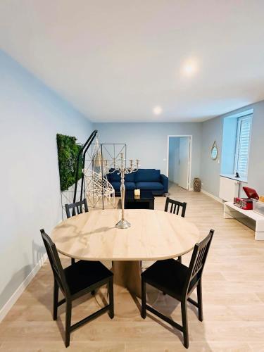 - une table à manger et des chaises dans le salon dans l'établissement Le Maçonnais - HYPER CENTRE MACON - PARKING GRATUIT - A 600m DE LA GARE, à Mâcon