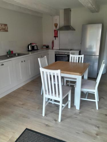 a kitchen with a table and chairs and a refrigerator at K2Cottages in Kilday