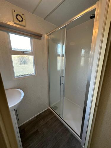 a bathroom with a shower and a sink at Caravan in Mablethorpe