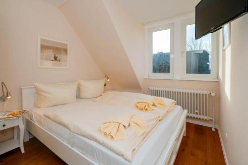 a white bed in a room with a window at Ferienhaus Sprotte in Tinnum