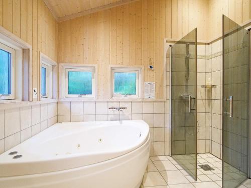 y baño con bañera y ducha acristalada. en 10 person holiday home in Gr sted, en Udsholt Sand
