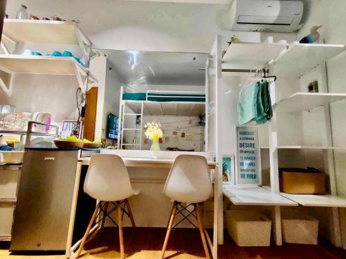 eine Küche mit zwei weißen Stühlen und einer Theke in der Unterkunft Balai Nami in Pajak