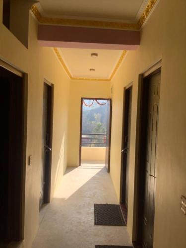 an empty hallway with a door and a window at Countryside Comfort Homestay in Nagarkot