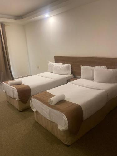 two beds in a hotel room with two at Rest-Inn Furnished Apartments ريست-ان للشقق المفروشة in Muscat