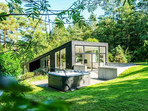 a modern house with a tub in the yard at 8 person holiday home in Ebeltoft in Ebeltoft