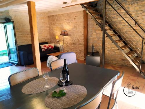 - une salle à manger avec une table et des verres à vin dans l'établissement la bulle de Chapaize, à Chapaize