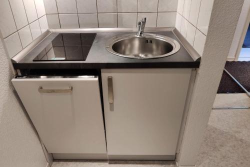 ein Bad mit einem Waschbecken und weißen Schränken in der Unterkunft Steinhuder Meer Ferienhaus Schwalbennest in Neustadt am Rübenberge