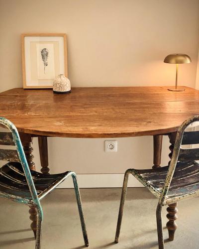 a wooden table with a lamp and two chairs at Felix - Maison d'hôtes in Néffiès