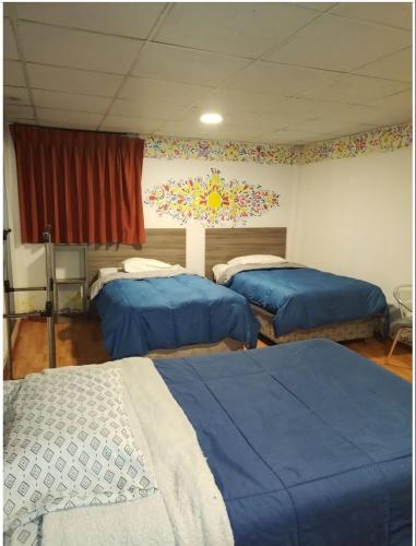 sypialnia z 3 łóżkami i ścianą z oknem w obiekcie Casa San Francisco w Cuzco