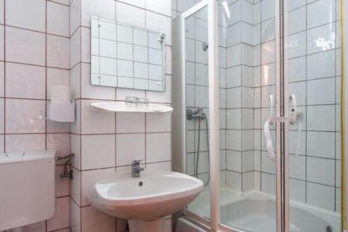 a bathroom with a sink and a shower and a toilet at Hotel Alice in Băile Olăneşti