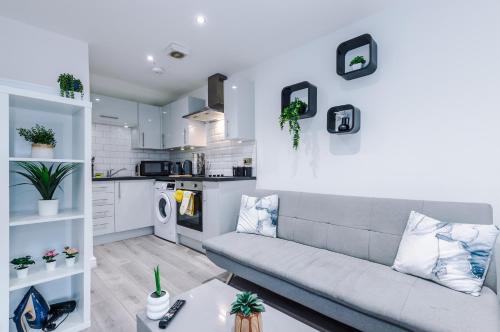 a living room with a couch and a kitchen at Modern Studio Apartment in Wigan in Hindley