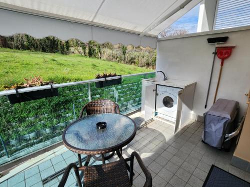 eine Terrasse mit einem Tisch und Stühlen sowie einer Waschmaschine in der Unterkunft A casa di Nala in Tortoreto Lido