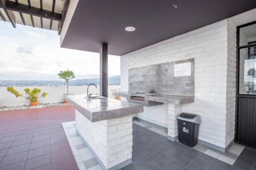 a kitchen with a sink and a large window at Mumbai Penthouse Studio in Quito