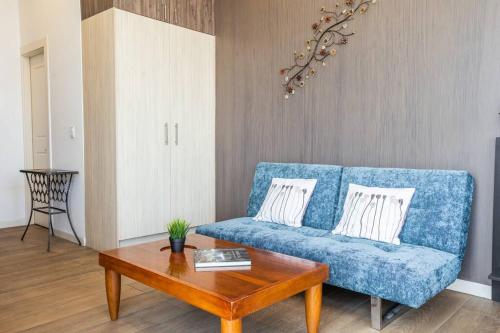 - un salon avec un canapé bleu et une table basse dans l'établissement Mumbai Penthouse Studio, à Quito