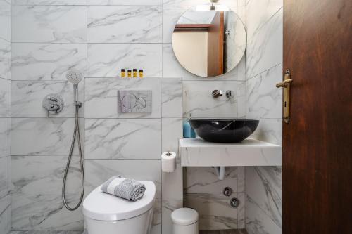 a bathroom with a toilet and a sink and a mirror at Katerina Studios in Naxos Chora