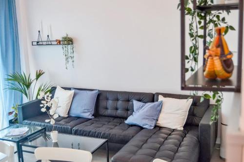 ein Wohnzimmer mit einem braunen Sofa mit blauen und weißen Kissen in der Unterkunft Casa Felipe 5 in Tijoco de Abajo