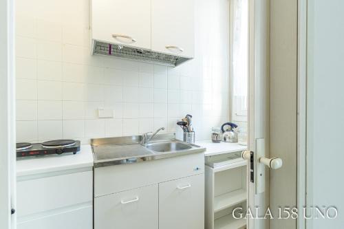 a white kitchen with a sink and a counter at Gala158UNO in Bologna