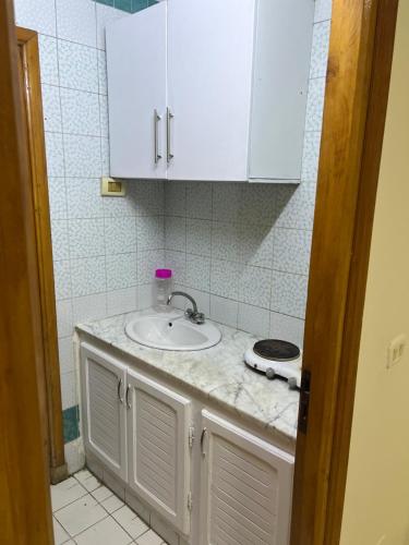 a bathroom with a sink and white cabinets at ستوديو فينيسيا in Sfax