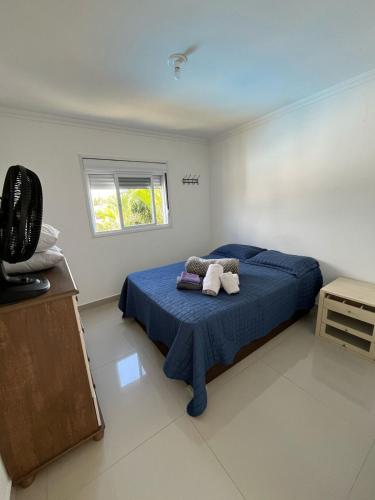 Casa com piscina في كاباو دا كانوا: غرفة نوم بسرير ازرق ونافذة