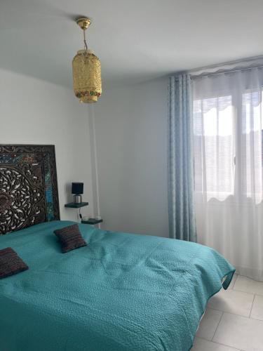 une chambre avec un lit vert et une fenêtre dans l'établissement House of Essia, à Aix-en-Provence