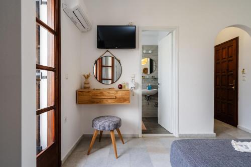 a room with a chair and a mirror and a sink at Katerina Studios in Naxos Chora