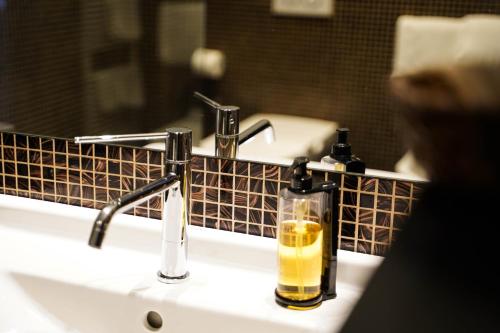 a bathroom sink with a bottle of soap on it at Hotel La Rocca in Nogarole Rocca