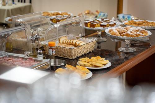Hotel Iris في جينوا: بوفيه مع مختلف المعجنات والمعجنات على الطاولة