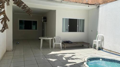 a patio with a table and chairs and a pool at Casa de 2 QUARTOS COM PISCINA in Balneário Camboriú