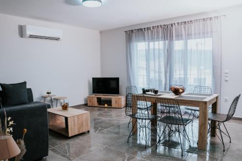 a living room with a table and chairs and a tv at Pamvotis Urban Suites in Ioannina