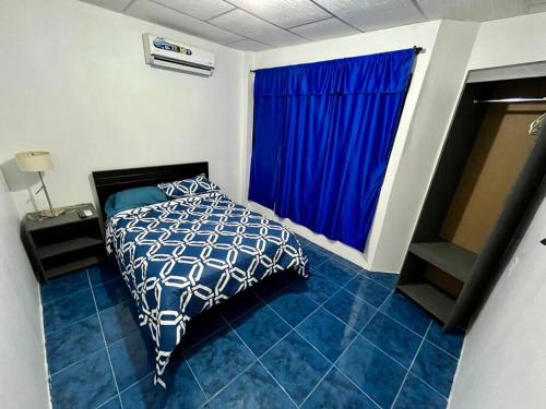 a bedroom with a bed and a large window at Hospedaje El Descanso CERCA CONSULADO AMERICANO GUAYQUIL in Guayaquil