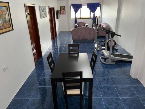 sala de estar con mesa y sillas y gimnasio en Hospedaje El Descanso CERCA CONSULADO AMERICANO GUAYQUIL en Guayaquil