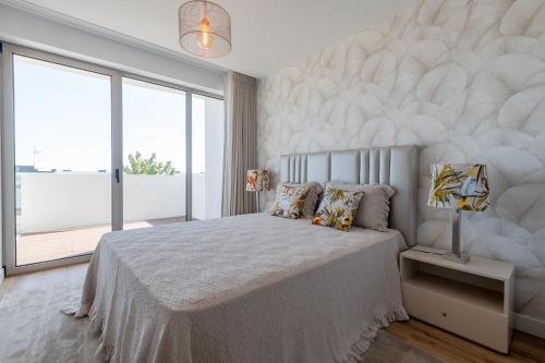 Un dormitorio con una cama grande y una ventana grande en The Prince Apartment, en Funchal
