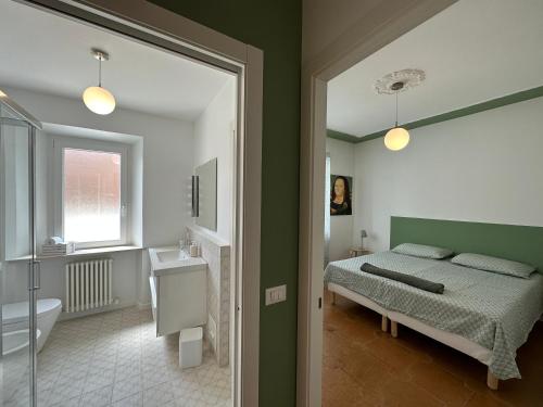 een slaapkamer met een bed en een badkamer met een wastafel bij Green House Camerano in Camerano