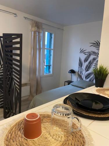 una habitación con una mesa con una taza de cristal en Appartement proche Disneyland, en Bailly-Romainvilliers