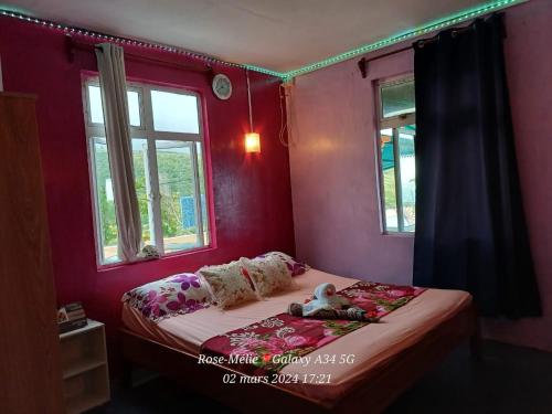 un pequeño dormitorio con una cama con un osito de peluche. en Chez Tonio Magic Ocean View en Rodrigues Island