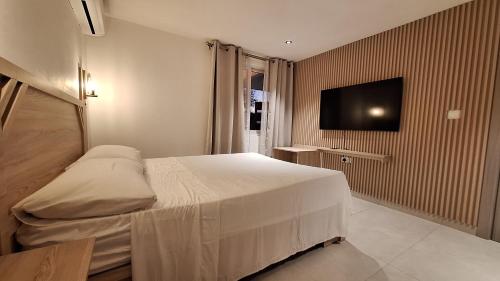 um quarto com uma cama e uma televisão de ecrã plano em Residence Capri em Mont Choisy