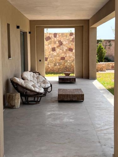 a patio with two chairs and a table and a window at Villa Maria, Luxury Marrakech in Marrakesh