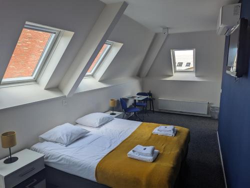 a bedroom with a bed with two towels on it at 1851 Bar - Hotel - Cinema in Wijk bij Duurstede