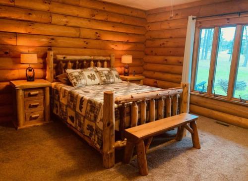 a bedroom with a bed and a bench in a log cabin at The Forest Edge Cabin in Sigel