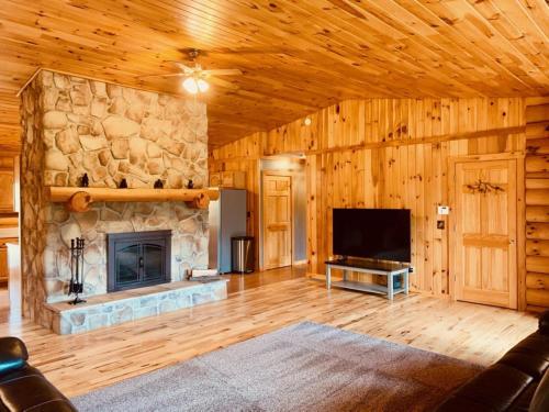 a living room with a fireplace and a stone wall at The Forest Edge Cabin in Sigel